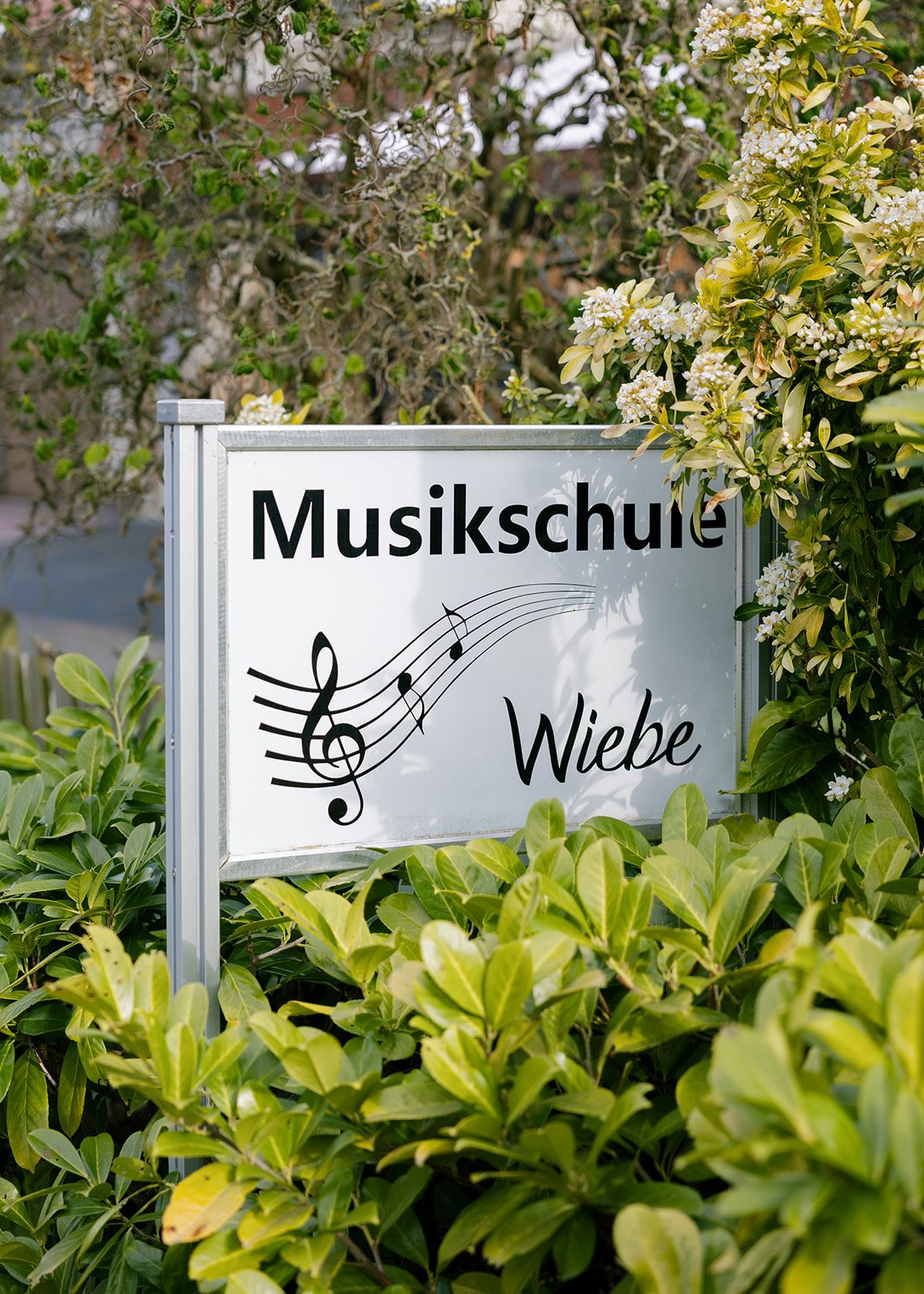 Schild der Musikschule Wiebe, eingebettet in Grün – Weißdornstraße 74, Espelkamp.